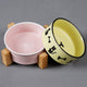 2 Gamelles pour chat design en céramique colorée de forme arrondie rose et jaune et la jaune est penchée vers la droite